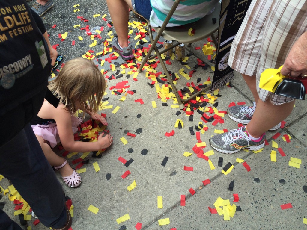 A girl picks up German-colored confetti from the ground prior to Sunday's game. (Adam Hermann - The Triangle)