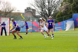 Midfielder Lacey Aghazarian cradles the ball against James Madison University. The women’s lacrosse team topped Elon, 10-7, April 19. (Ajon Brodie - The Triangle)